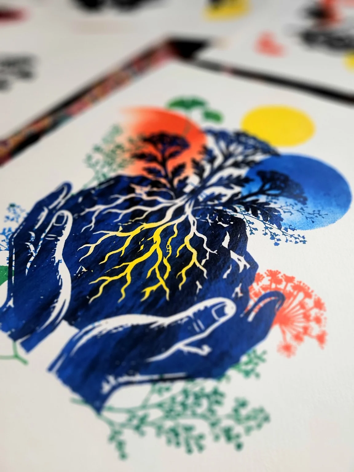Sérigraphie colorée représentant des mains, des racines et des arbres